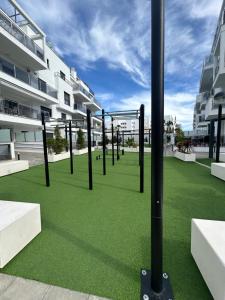 a group of poles on a lawn in front of a building at LM APARTAMENTOS Aguacate Costa Tropical in Motril