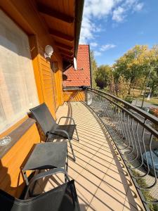 two chairs sitting on the balcony of a house at Beach Apartman by HelloBalatonlelle in Balatonlelle