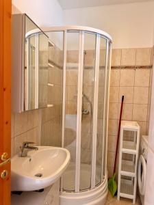 un baño con ducha y lavabo en Beach Apartman by HelloBalatonlelle, en Balatonlelle