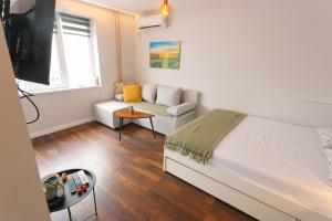 a bedroom with a bed and a couch at Serdica Tower View DT Parking Wi-Fi AC in Sofia