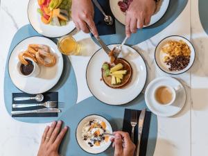 a group of people sitting around a table eating food at Hotel Don Juan Tossa in Tossa de Mar