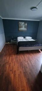 a bedroom with a bed and a wooden floor at Comfortable apartment near the city center and nature 