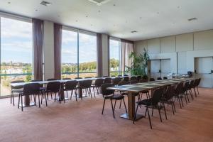 a conference room with tables and chairs and windows at Hotel de Guimaraes Business & SPA in Guimarães +255 photos