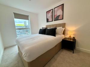 a bedroom with a large bed and a window at Luxury 2 bed Apt Near Ascot & Windsor in Bracknell