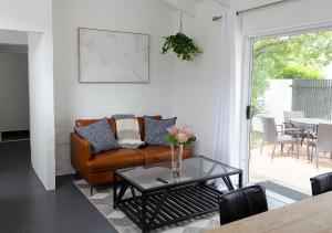 a living room with a couch and a table at 1 bedroom cottage south of Cape Town in Marina Da Gama