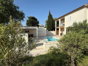 a villa with a swimming pool in front of a house at Ferienhaus FILI Insel Murter mit privaten Pool und großer Terrasse in Murter