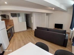 a living room with a couch and a kitchen at Bel appartement au centre du vieux Nyons en Drôme Provençale in Nyons +14 photos
