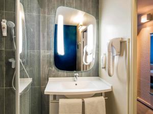 ein Badezimmer mit Waschbecken und Spiegel in der Unterkunft ibis Tours Nord in Tours + 116 Fotos