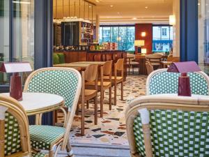 a restaurant with tables and chairs and a bar at Mercure Paris Butte Montmartre Basilique in Paris