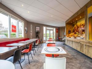 a restaurant with tables and chairs in a room at ibis Chalons en Champagne in Châlons-en-Champagne