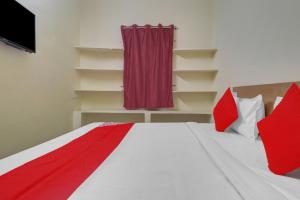 a bedroom with a bed with red and white pillows at Hotel O RBS Square Langer Houz in Hyderabad +18 photos