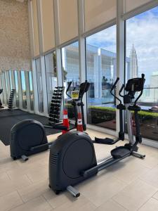 Un gimnasio con cintas de correr y elípticas en un edificio. en PLATINUM SUITES KLCC By RAISA, en Kuala Lumpur