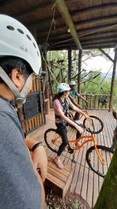 two people wearing helmets sitting on bikes on a deck at Refúgio Rio do Boi in Praia Grande