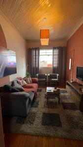 a living room with a couch and a table at Casa Flores na Janela in Socorro