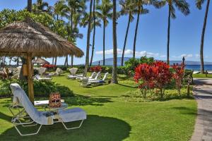 カアナパリにあるKaanapali Alii 385 · ALII 385 Corner 2BD OceanFront Dream Vacatiの長椅子とヤシの木と海のある芝生