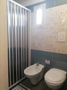 a bathroom with a white toilet and a sink at Casa Vacanze Lu Rizzaru in Nardò