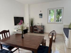 a living room with a wooden table and a couch at Ferienhaus FILI Insel Murter mit privaten Pool und großer Terrasse in Murter
