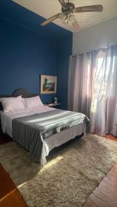 a bedroom with a bed and a ceiling fan at Casa Flores na Janela in Socorro +6 photos