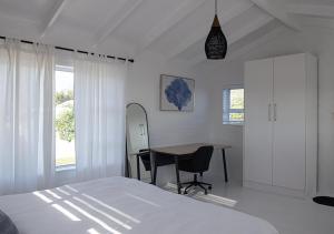a bedroom with a bed and a desk and a table at 1 bedroom cottage south of Cape Town in Marina Da Gama