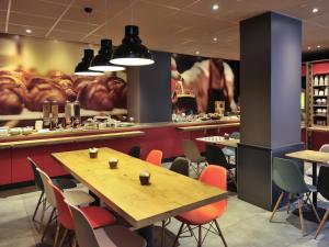 a restaurant with tables and chairs and a large mural at ibis Lyon Centre in Lyon