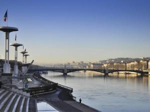 a bridge over a river with a person standing next to it at ibis Lyon Centre in Lyon