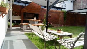 un patio avec deux chaises, une table et un parasol dans l'établissement AMALIA departamentos, à San Rafael 4 autres photos