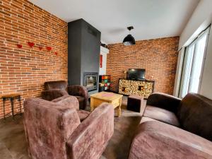 ein Wohnzimmer mit 2 Sofas und einer Ziegelwand in der Unterkunft Villa Ici et Ailleurs, entre mer et forêt in La Tranche-sur-Mer