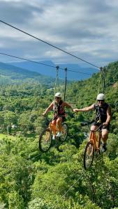 two people riding bikes on a hill with swings at Refúgio Rio do Boi in Praia Grande