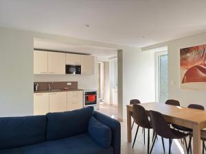 a living room with a blue couch and a table at Le Mesnil in Bayeux