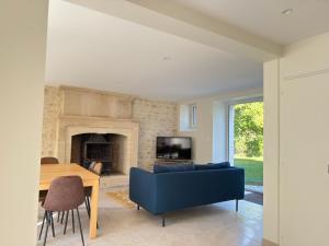 a living room with a blue couch and a table at Le Mesnil in Bayeux +18 photos