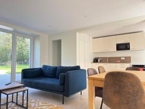 a living room with a blue couch and a table at Le Mesnil in Bayeux