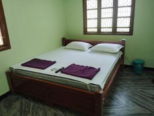 ein Bett in einem Zimmer mit zwei Handtüchern darauf in der Unterkunft Kirubai Homestay in Tiruchchendūr