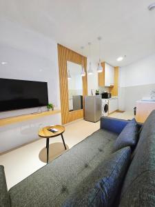 a living room with a couch and a tv at Summer Studio Apartment at Kota Kinabalu City Centre in Kota Kinabalu