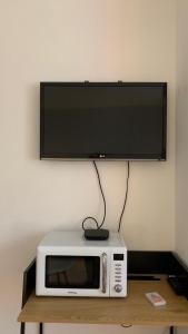 Un microondas con un televisor de pantalla plana encima. en Suite dans maison provençale chez l'habitant, en Château-Arnoux-Saint-Auban