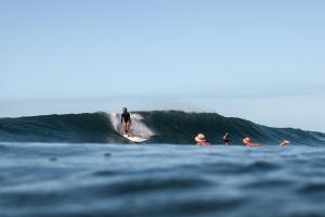 a man riding a wave on a surfboard in the ocean at Hostal Ojo de Agua in Transito