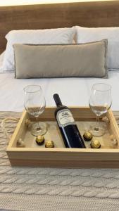 ein Holztablett mit einer Flasche Wein und zwei Gläsern in der Unterkunft Flat em Itaipava! in Araras Petropolis
