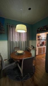 a dining room with a wooden table and chairs at Casa Flores na Janela in Socorro