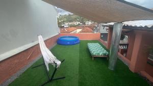 an umbrella and a bench on a balcony at Casa Flores na Janela in Socorro +2 photos