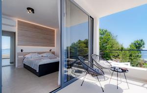 une chambre avec un lit et un balcon avec vue dans l'établissement Villa Evia by Villas Guide, à Prižba 27 autres photos