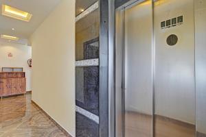 a hallway with a glass elevator in a building at FabHotel Pranavam Residency in Tirupati
