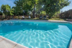 een zwembad met blauw water in een tuin bij Les Cezennes in Saint-Ambroix +47 foto's