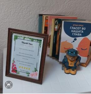 a stuffed animal sitting in front of books on a shelf at Park Apartment in Kochani