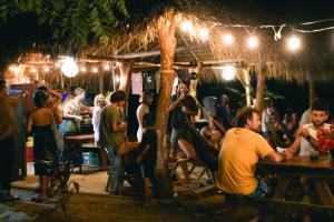 a group of people sitting at a bar at night at Hostal Ojo de Agua in Transito