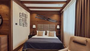 a bedroom with a bed and a chair at Grey Family Hotel in Kopaonik +30 photos