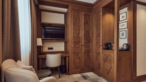 a living room with a tv and a couch and a chair at Grey Family Hotel in Kopaonik