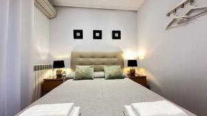 ein Schlafzimmer mit einem großen Bett mit zwei Tischen und zwei Lampen in der Unterkunft Habitaciones en Toledo in Madrid