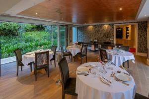 a dining room with white tables and chairs at The 506 Hotel in Midrand