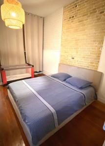 a bed in a room with a brick wall at Spacieux et élégant proche plage Le Havre Coty in Le Havre +14 photos