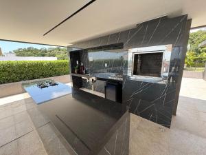 a kitchen with a black counter top in a house at Beira-mar do Cabo Branco com varanda UN113 in Penha