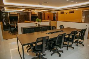 a conference room with a table and black chairs at Beira-mar do Cabo Branco com varanda UN113 in Penha +50 photos
